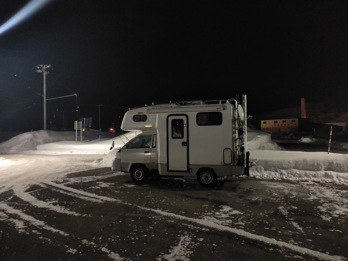 夜の駐車場とキャンピングカー